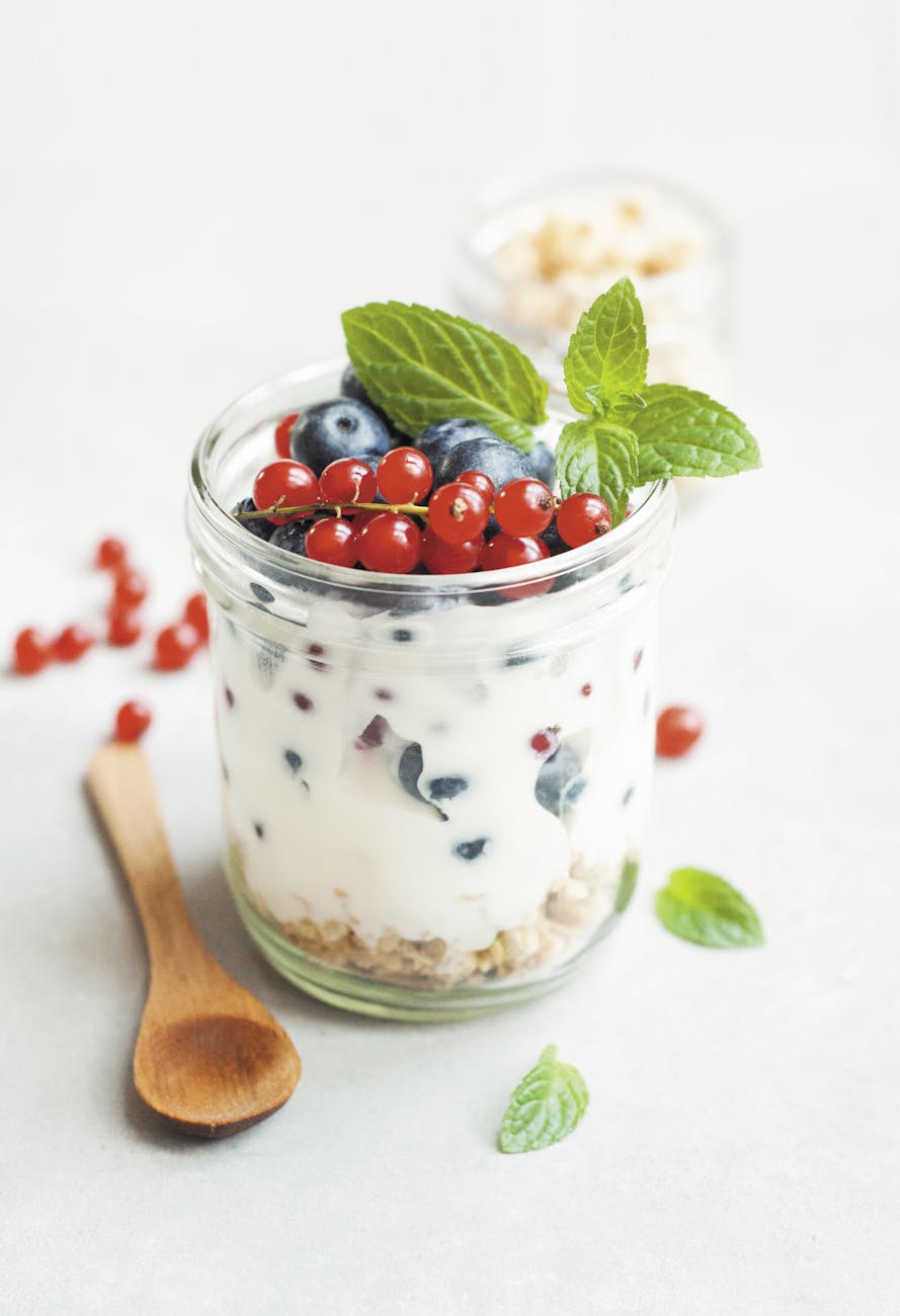 a jar of yogurt with berries and a spoon